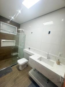 a bathroom with a toilet and a sink and a shower at Locação Terras de São Francisco, Quarto Flamboyant in Andradas