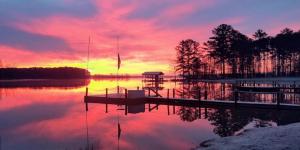 a sunset over a body of water with a dock at Weiss Lake Lodge in Centre