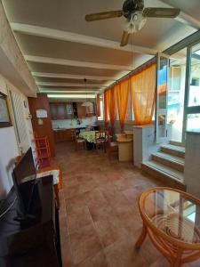 ein Wohnzimmer mit einem Deckenventilator und ein Esszimmer in der Unterkunft 2 bedrooms property with shared pool at Porto Cesareo 1 km away from the beach in Porto Cesareo