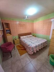 um quarto com uma cama e uma cadeira em 2 bedrooms property with shared pool at Porto Cesareo 1 km away from the beach em Porto Cesareo