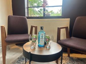 a table with two chairs and a bottle and two glasses at Park View is a beautiful whole entire house close to town centre, sleeps 8 in 4 rooms, 2 doubles and 4 single beds with 2 shower rooms, available for holidays, insurance stays, trades people, contractors, pets welcome in Wisbech