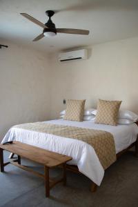 una camera con un grande letto e un ventilatore a soffitto di Villa Quetzalpapalotl a Pérula