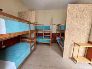 a room with three bunk beds and a table at Lonko Hostel in Arequipa