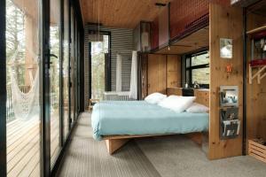 ein Schlafzimmer mit einem Bett und einem Balkon in der Unterkunft Cabin Zoobox 81 in Eastman