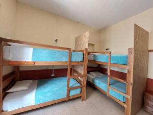 a room with three bunk beds in a room at Lonko Hostel in Arequipa