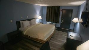 a hotel room with a bed and two lamps at Ashley Motel in Plainfield