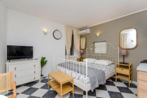 a bedroom with a white bed and a tv at Apartments Urban in Split