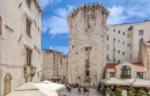 a group of people walking in front of a tall stone building at Apartments Urban in Split