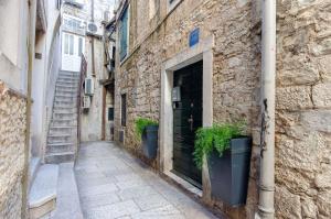 an alley with two potted plants next to a building at Apartments Urban in Split