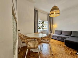 uma sala de estar com uma mesa e cadeiras e um sofá em LM art apartments em Porto