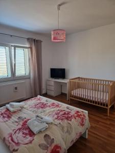 - une chambre avec un lit, un lit bébé et une télévision dans l'établissement House Iva Luca, à Radošinovac