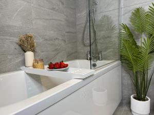 a bathroom with a bath tub with a bowl of fruit at Modern One-Bedroom Apartment in Swindon