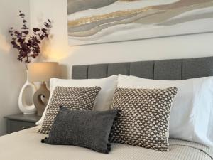 Modern One-Bedroom Apartment في سويندون: غرفة نوم بسرير ومخدات ولوحة