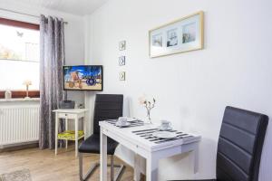 Habitación con escritorio blanco y 2 sillas. en Ostseeliebe, gemütliche und moderne Ferienwohnung für 2 Personen in Zingst, en Zingst