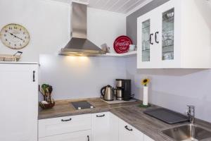 a kitchen with a sink and a clock on the wall at Ostseeliebe, gemütliche und moderne Ferienwohnung für 2 Personen in Zingst in Zingst