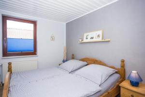 sypialnia z łóżkiem i oknem w obiekcie Ostseeliebe, gemütliche und moderne Ferienwohnung für 2 Personen in Zingst w Zingst
