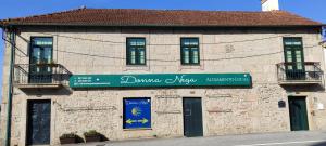 a building with a sign on the side of it at Donna Nega Alojamento Local in Caminha