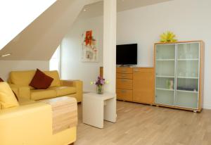 バースにあるDarßblick, Penthouse-Wohnung für 4 Personen mit Meerblick in Barthのソファとテレビのあるリビングルーム