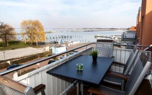 バースにあるDarßblick, Penthouse-Wohnung für 4 Personen mit Meerblick in Barthの水辺の景色を望むバルコニー(テーブル、椅子付)