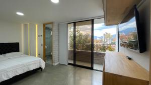 a bedroom with a bed and a large window at Edificio Helena in Medellín