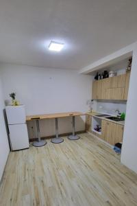 an empty kitchen with a table and a refrigerator at Vila Ohana in Skopje