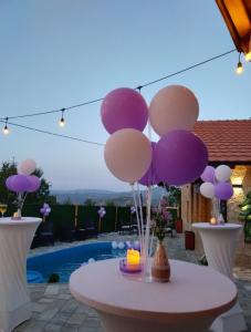 a table with purple and white balloons on it at Vila Ohana in Skopje