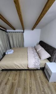 a bedroom with a bed and a wooden floor at Villa Ohana in Skopje +10 photos