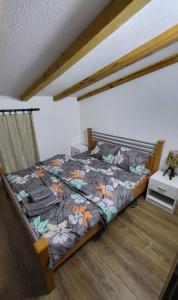 a bedroom with a bed with a floral comforter at Vila Ohana in Skopje