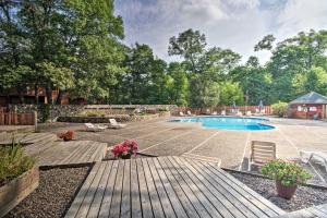 a backyard with a swimming pool and a wooden deck at Nisswa Townhome with Boat Slip and Gull Lake Access! in Nisswa