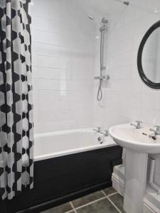 a bathroom with a sink and a bath tub and a sink at Ger y mor in Barmouth