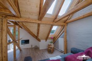 una sala de estar con techos de madera y vigas de madera. en Auszeit im Harz - Haus 2 Wohnung 5, en Schierke