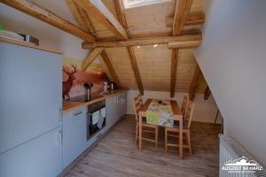 een keuken met houten plafonds en een tafel en stoelen bij Auszeit im Harz - Haus 2 Wohnung 5 in Schierke