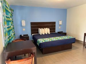 Un dormitorio con una cama y una mesa con una mesa. en American Inn Punta Gorda en Punta Gorda