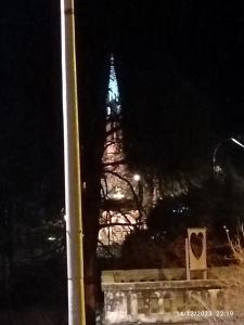 una torre de reloj por la noche con una torre iluminada en Chez Marie et Didier Chalet saint Jacques en Lourdes