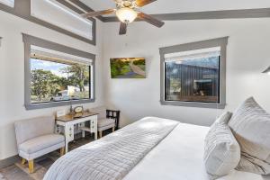 a bedroom with a bed and a desk and two windows at 7A Ranch in Wimberley