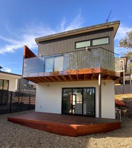 una casa con terrazza e balcone di The Lake House & Apartment a Merimbula