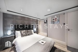 - une chambre avec un lit et un panneau indiquant les séjours électriques dans l'établissement Hackney Suites - En-suite rooms & amenities, à Londres