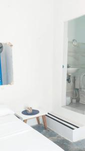 a white room with a table and a toilet at La Marina Hostal in Ríohacha