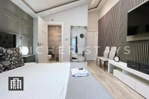 a bedroom with a large bed and a bathroom at Hackney Suites - En-suite rooms & amenities in London