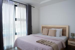 a bedroom with a large bed and a window at Luxurious 2 Bedroom The Edge Labone in Accra