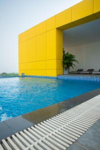 a swimming pool with a yellow wall and blue water at Luxurious 2 Bedroom The Edge Labone in Accra