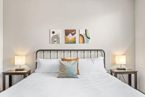 a bedroom with a white bed with two side tables at Stunning Westgate CozySuites by stadium with pool 5 in Glendale