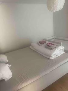 białe łóżko z dwoma kocami i poduszkami w obiekcie Beautiful house in peaceful area w mieście Vantaa