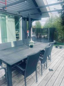 una mesa de madera y sillas en una terraza con mesa en Beautiful house in peaceful area en Vantaa