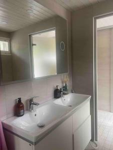 W łazience znajduje się biała umywalka i lustro. w obiekcie Beautiful house in peaceful area w mieście Vantaa