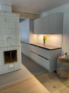 cocina con armarios blancos y encimera con horno en Beautiful house in peaceful area, en Vantaa