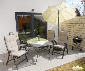 einen Tisch und Stühle mit Sonnenschirm auf einer Terrasse in der Unterkunft Auszeit-im-Harz Haus 6 Wohnung 3 in Wernigerode