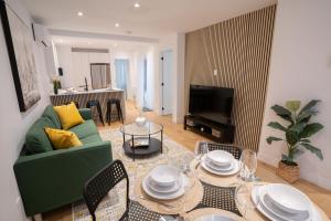 ein Wohnzimmer mit einem grünen Sofa und einem Tisch in der Unterkunft Beautifully Renovated 3BR Downtown 2min to METRO in Montreal