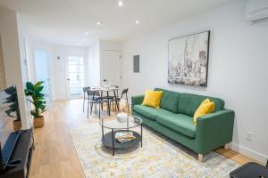 uma sala de estar com um sofá verde e uma mesa em Beautifully Renovated 3BR Downtown 2min to METRO em Montreal