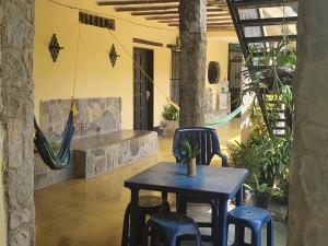 eine Terrasse mit einem Tisch, Stühlen und einer Hängematte in der Unterkunft Casa Nova in Puerto Colombia